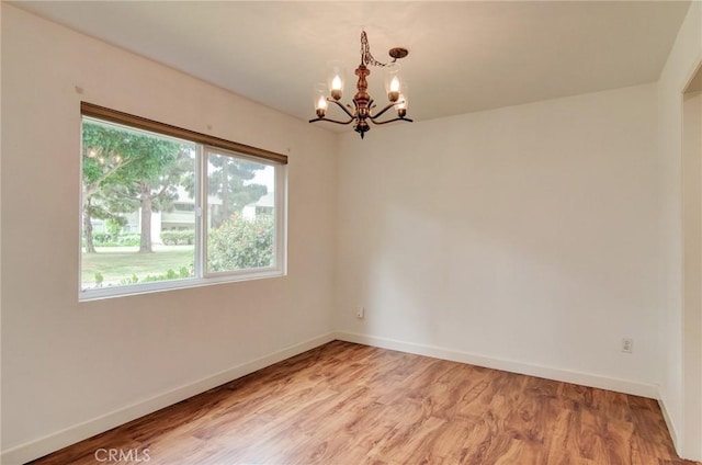 8566 Van Ness Ct Unit 21D, Huntington Beach, CA 92646 - spare room featuring a chandelier, baseboards, and light wood-style flooring