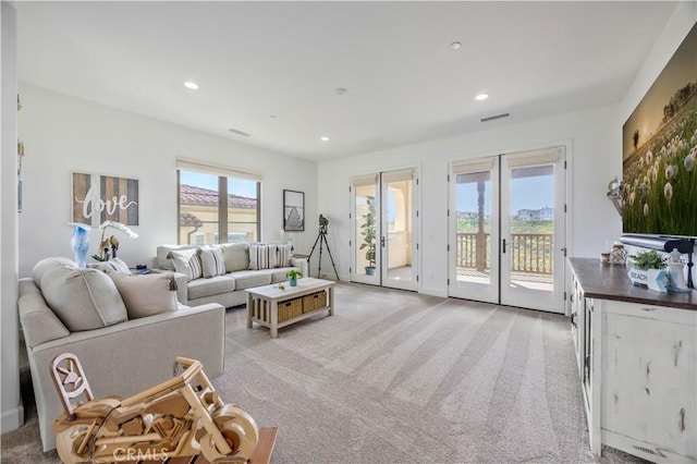 living room with recessed lighting, visible vents, light carpet, and french doors