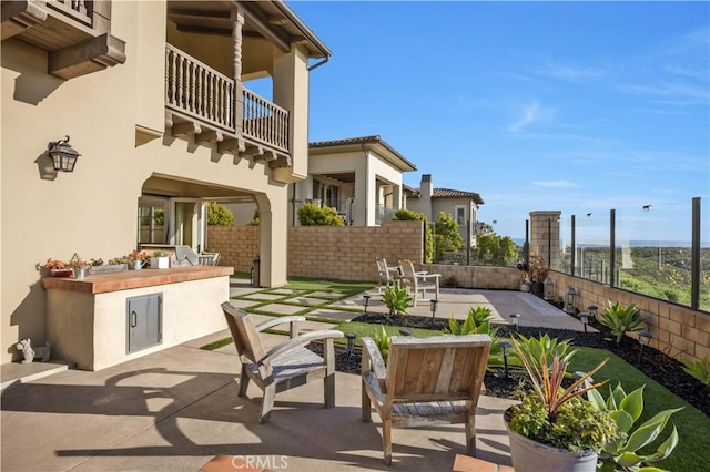 view of patio with a fenced backyard, area for grilling, and a balcony