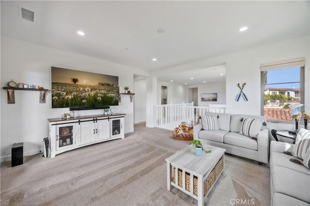 carpeted living area with visible vents, recessed lighting, and baseboards