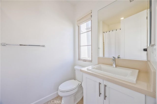 full bath featuring vanity, baseboards, and toilet
