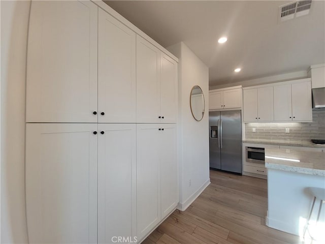 27078 Painted Sky Way, Valencia, CA 91381 - kitchen with appliances with stainless steel finishes, white cabinets, recessed lighting, light wood-style flooring, and backsplash