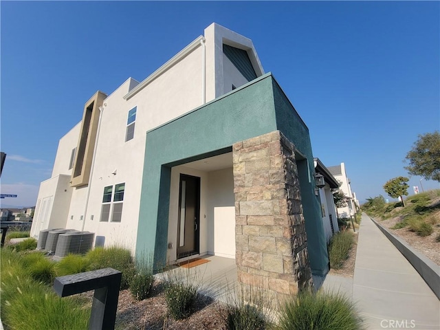 27078 Painted Sky Way, Valencia, CA 91381 - view of side of property featuring stucco siding, stone siding, and central AC