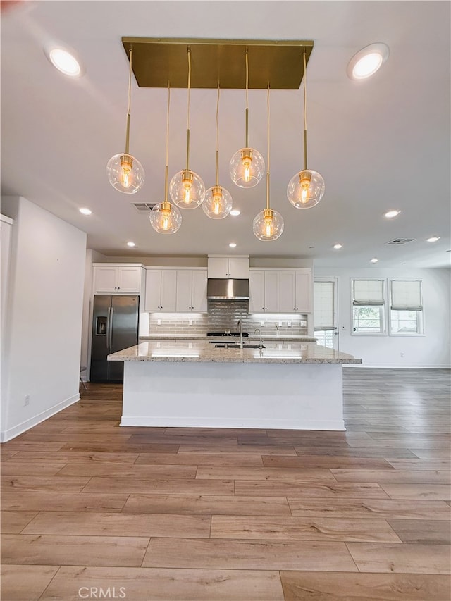 27078 Painted Sky Way, Valencia, CA 91381 - kitchen with stainless steel fridge, under cabinet range hood, white cabinets, light wood-style flooring, and recessed lighting