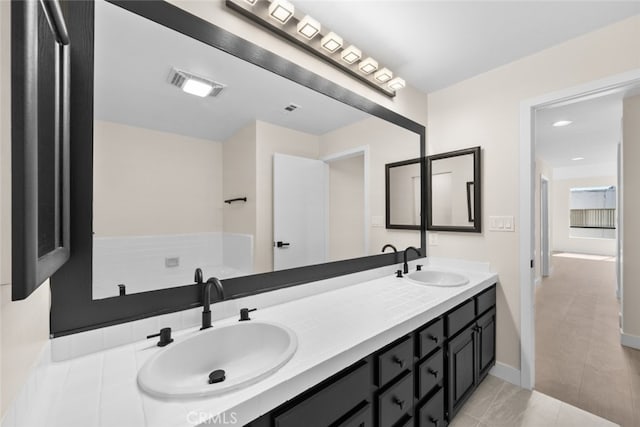 full bathroom featuring double vanity, a sink, baseboards, and visible vents