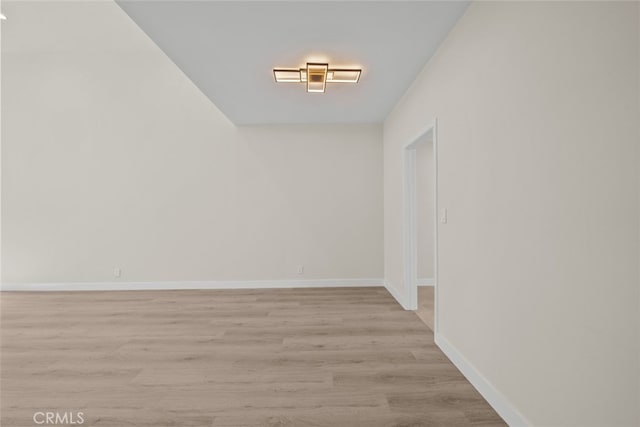 empty room featuring baseboards and light wood-style floors