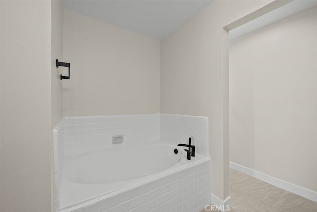 bathroom with tile patterned floors, a garden tub, and baseboards