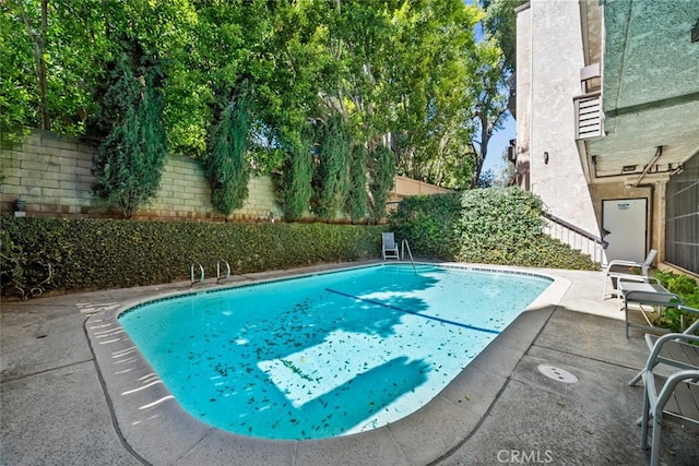 view of swimming pool with a patio, a fenced in pool, and a fenced backyard