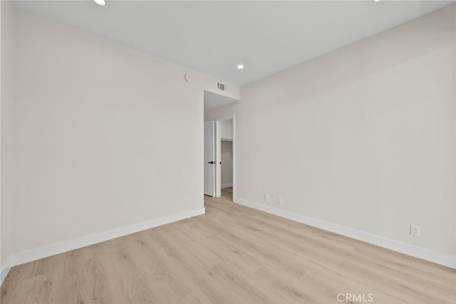 empty room featuring baseboards, visible vents, wood finished floors, and recessed lighting