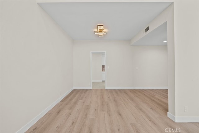 empty room featuring visible vents, baseboards, and light wood-style floors