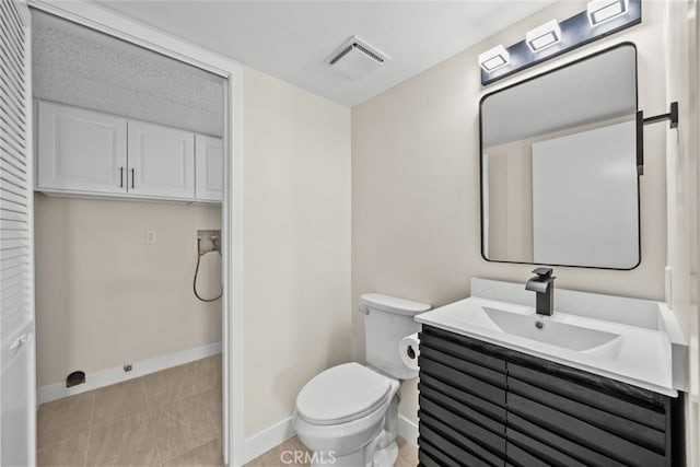 half bath with visible vents, toilet, vanity, and baseboards