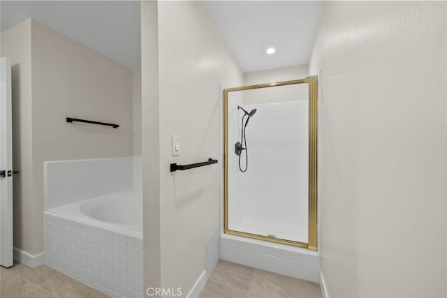 bathroom with baseboards, a shower stall, tile patterned flooring, and a bath