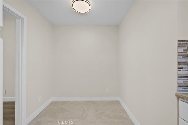 spare room with baseboards