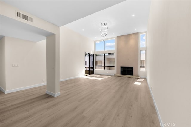 unfurnished living room with visible vents, baseboards, and light wood-style floors