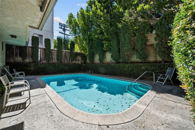 view of swimming pool featuring a patio, a fenced in pool, and a fenced backyard