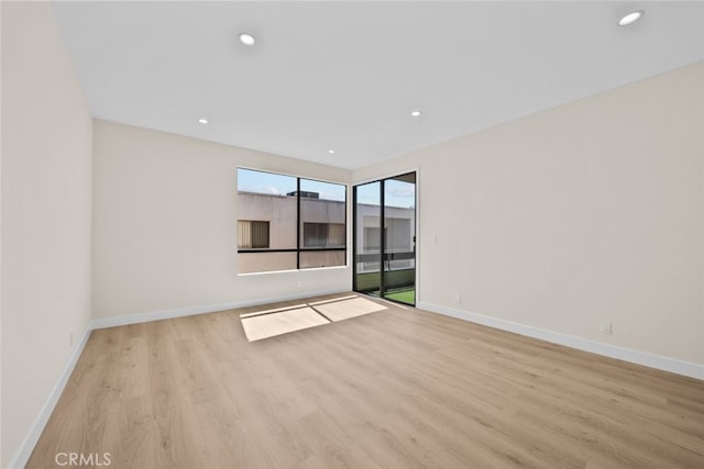 unfurnished room with recessed lighting, light wood-style flooring, and baseboards