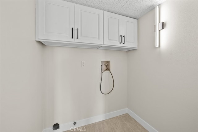 laundry area featuring baseboards, hookup for a washing machine, and cabinet space