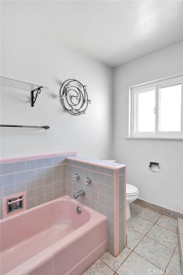 bathroom featuring a bath, toilet, and tile patterned flooring