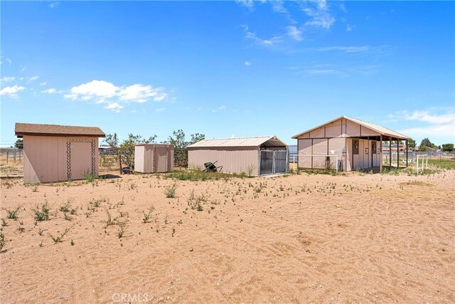 view of yard with an outdoor structure, a carport, and fence