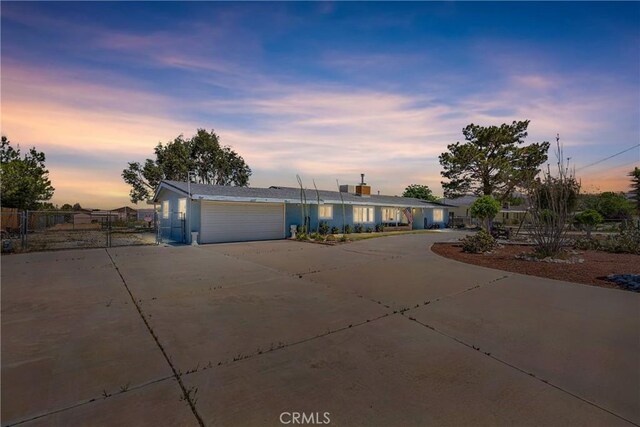 view of front of home with a garage, concrete driveway, and fence