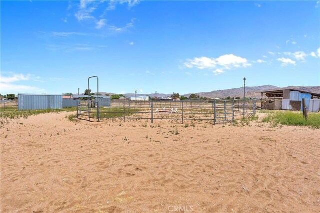 view of yard with a rural view, an outbuilding, a mountain view, and an exterior structure