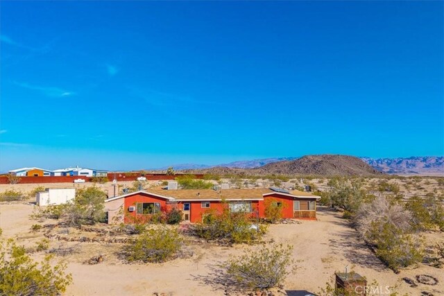 view of front of property featuring a mountain view and a desert view