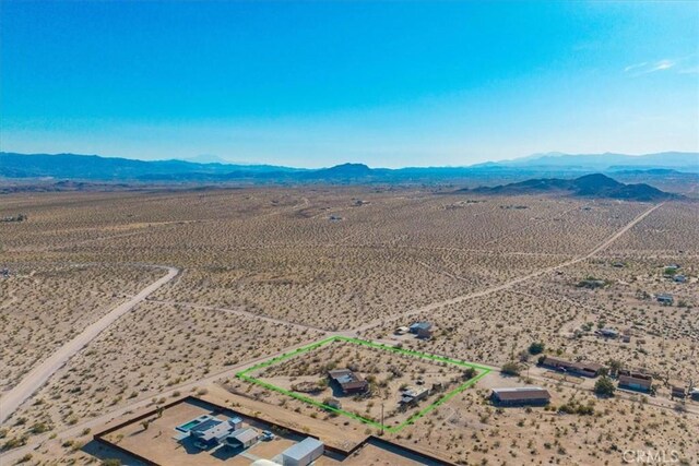 birds eye view of property featuring a mountain view, a desert view, and a rural view