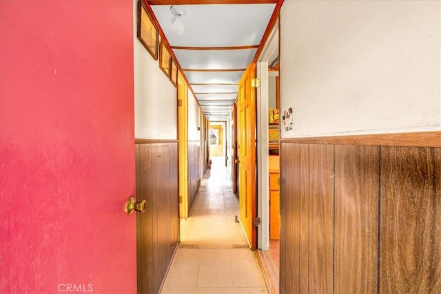 hallway featuring wainscoting and wood walls