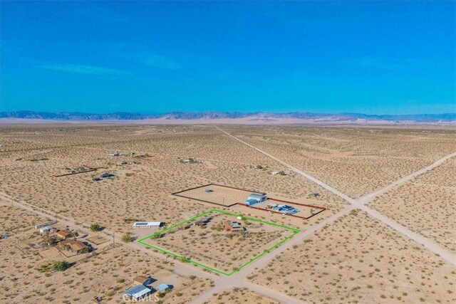 drone / aerial view with a rural view, view of desert, and a mountain view