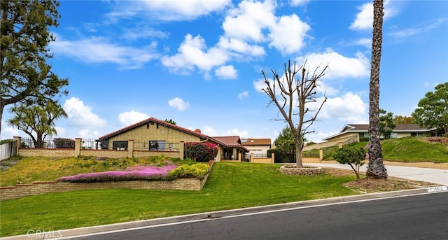 ranch-style house featuring fence and a front yard