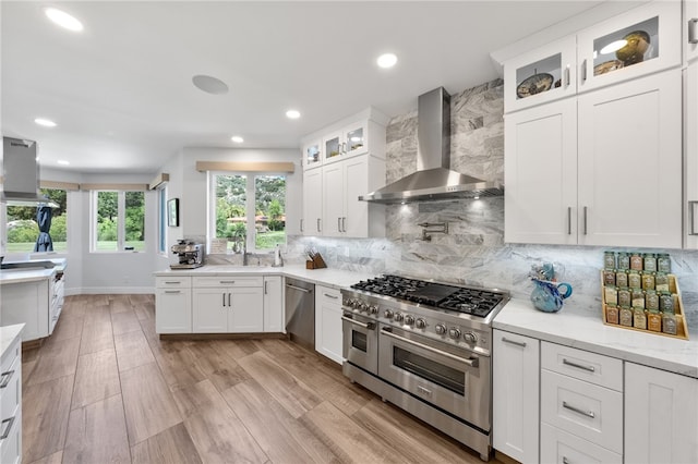 38101 Stone Meadow Dr, Murrieta, CA 92562 - kitchen with recessed lighting, backsplash, wall chimney range hood, appliances with stainless steel finishes, and white cabinetry