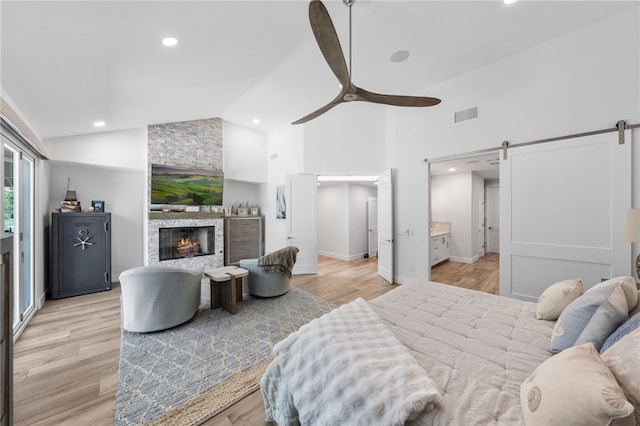 38101 Stone Meadow Dr, Murrieta, CA 92562 - bedroom featuring high vaulted ceiling, a barn door, light wood-style floors, visible vents, and recessed lighting
