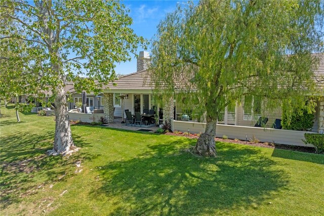 38101 Stone Meadow Dr, Murrieta, CA 92562 - back of house featuring a chimney, a yard, and a patio