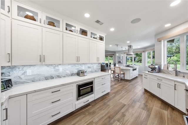 38101 Stone Meadow Dr, Murrieta, CA 92562 - kitchen featuring a sink, island range hood, decorative backsplash, white cabinets, and recessed lighting