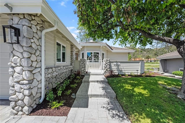38101 Stone Meadow Dr, Murrieta, CA 92562 - property entrance featuring stone siding, fence, a gate, and a yard
