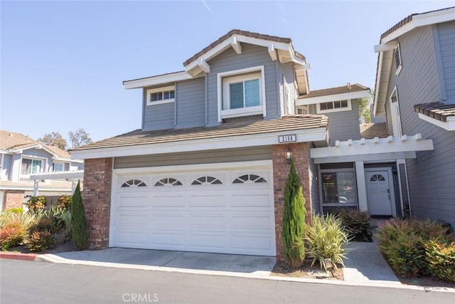 2196 Evergreen Dr, Tustin, CA 92782 - view of front facade with a garage, brick siding, and driveway