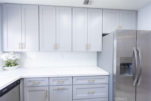 2196 Evergreen Dr, Tustin, CA 92782 - kitchen featuring appliances with stainless steel finishes, gray cabinets, tasteful backsplash, and light stone countertops