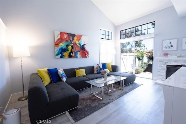 2196 Evergreen Dr, Tustin, CA 92782 - living room with wood finished floors, high vaulted ceiling, a fireplace, and baseboards