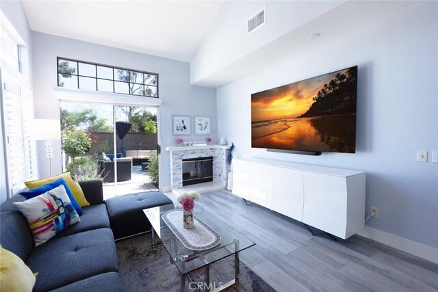 2196 Evergreen Dr, Tustin, CA 92782 - living area with wood finished floors, a fireplace, high vaulted ceiling, and baseboards