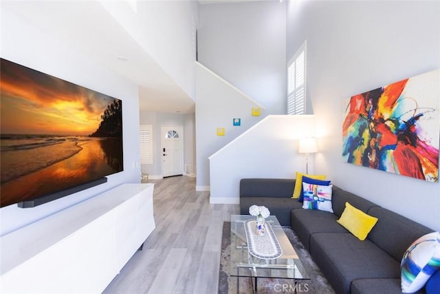 2196 Evergreen Dr, Tustin, CA 92782 - living room with wood finished floors, a towering ceiling, stairway, and baseboards