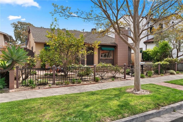 view of front of property featuring a front lawn, a shingled roof, and fence private yard