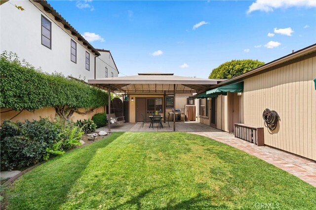 rear view of property with fence, a patio area, and a yard
