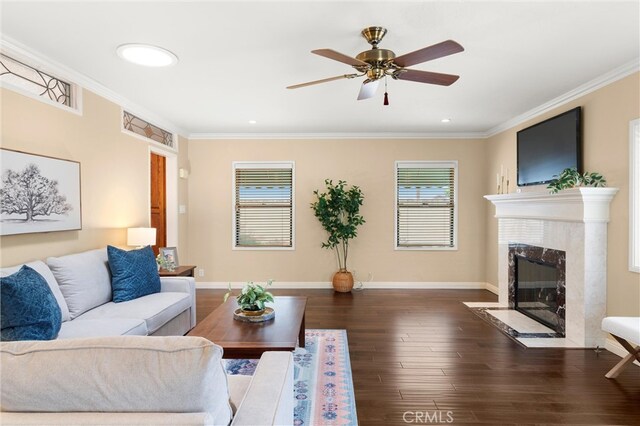 living room featuring baseboards, ornamental molding, wood finished floors, and a fireplace