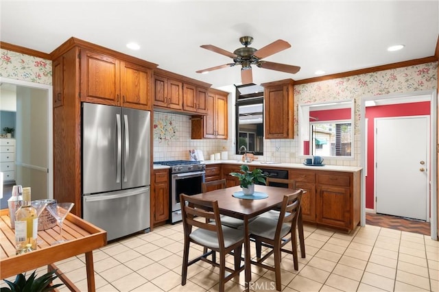 kitchen featuring stainless steel appliances, light tile patterned flooring, decorative backsplash, a ceiling fan, and brown cabinets
