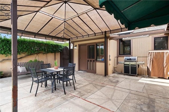 view of patio featuring area for grilling, fence, and outdoor dining space