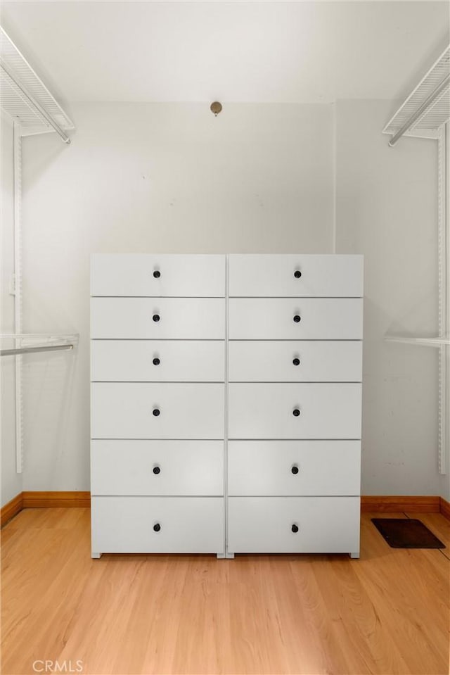 walk in closet with light wood-style flooring
