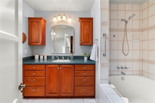 full bath featuring tile patterned flooring, vanity, and tiled shower / bath