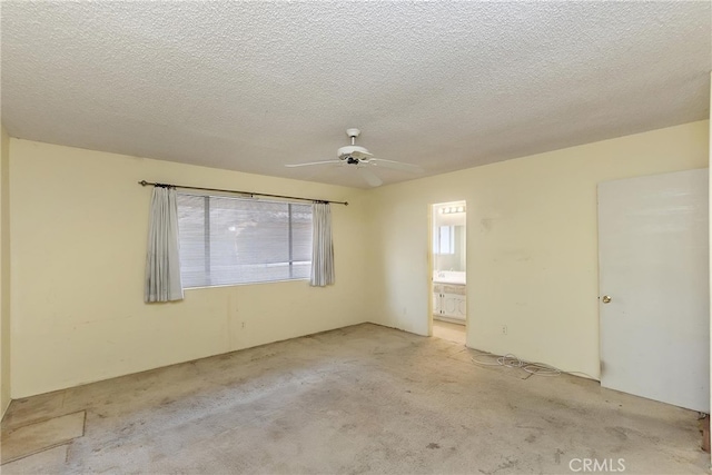 spare room featuring carpet flooring, a ceiling fan, and a textured ceiling