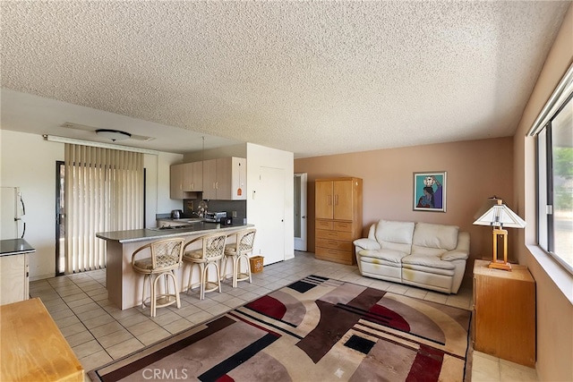 living room with a textured ceiling and light tile patterned floors