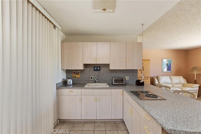 kitchen with stainless steel electric stovetop, a sink, a peninsula, open floor plan, and light brown cabinets